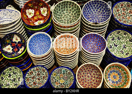 Assiettes en céramique du Grand Bazar Istanbul Turquie | ISTANBUL, Turquie — des rangées de bols et d'assiettes en céramique turque peints à la main sont exposées dans le Grand Bazar, leurs motifs floraux cobalt, turquoise et tomate-rouge typiques de l'artisanat. Les céramiques sont vendues sur le marché depuis des siècles aux côtés des bijoux et des textiles. Fondé par le sultan Mehmed II au milieu du XVe siècle, le bazar abrite aujourd'hui environ 3 000 à 4 000 boutiques dans les zones historiques d'Istanbul classées au patrimoine mondial de l'UNESCO. Banque D'Images