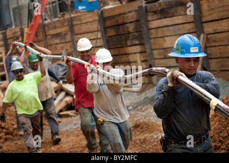 Les travailleurs de la construction réalisation d'un long morceau de câble sur un chantier à Washington, DC. Banque D'Images