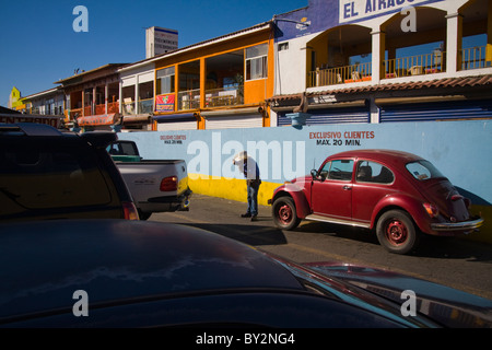 Un homme donne une camionnette directions dans un stationnement d'Ensenada, Baja California, Mexique. Banque D'Images