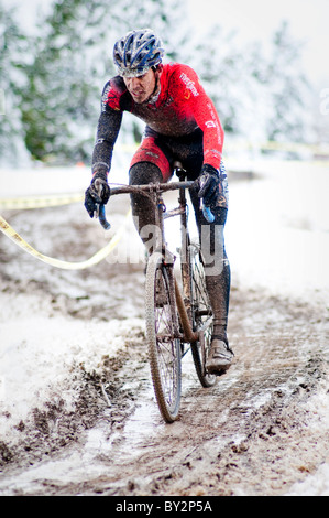 Les courses cyclistes un dans la boue et la neige lors d'une course de cyclocross à Boulder, CO. Banque D'Images
