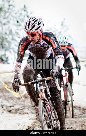 Les courses cyclistes un dans la boue et la neige lors d'une course de cyclocross à Boulder, CO. Banque D'Images