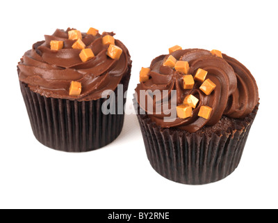 Cup Cakes chocolat authentique savoureux avec des morceaux de caramel fondant et desserts de givrage sur un fond blanc avec un chemin de détourage et aucun peuple Banque D'Images