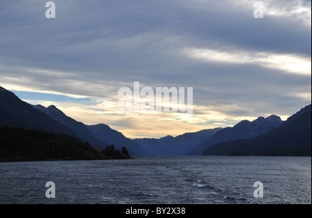 Coucher Soleil nuages gris foncé gris sur les eaux du Brazo Blest et silhouette des montagnes, Andes, Bariloche, Argentine Banque D'Images