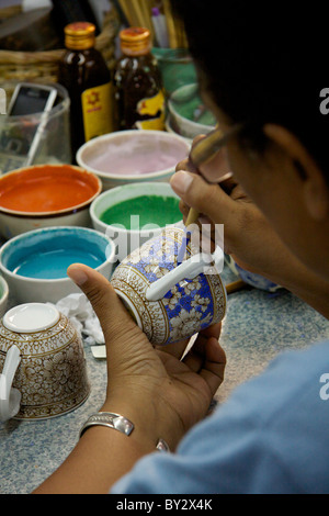 Une femme Le Benjarong peintures porcelaine tasses avec dans les glaçures Don Kai Dee Le Benjarong Village dans le district de Krathum Baen Banque D'Images