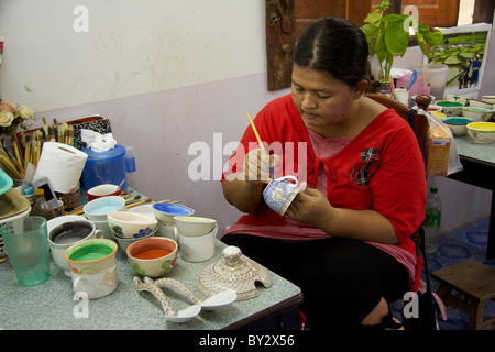 Une femme Le Benjarong peintures porcelaine tasses avec dans les glaçures Don Kai Dee Le Benjarong Village dans le district de Krathum Baen Banque D'Images