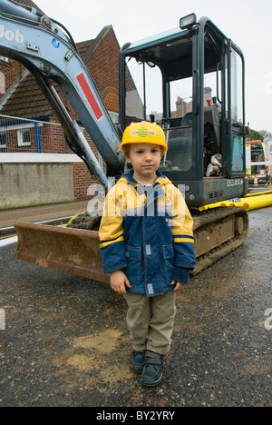 Garçon debout près de mini digger Banque D'Images