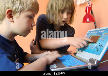 Deux enfants apprenant d'un enfants à l'ordinateur Banque D'Images