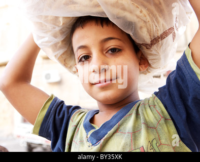 République boy carrying pain frais sur sa tête à Hama, en Syrie Banque D'Images