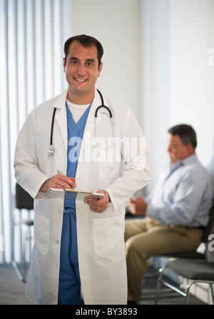USA, New Jersey, Jersey City, Portrait of doctor holding medical résultats avec male patient in background Banque D'Images