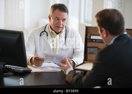 USA, New Jersey, Jersey City, Doctor résultats médicaux avec male patient in office Banque D'Images