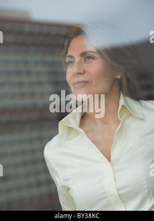 USA, New Jersey, Jersey City, Businesswoman looking through window Banque D'Images