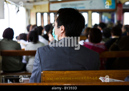 Masque de visage avec de banlieue sur Victoria Harbour Ferry Star entre Kowloon et l'île de Hong Kong. JMH4142 Banque D'Images