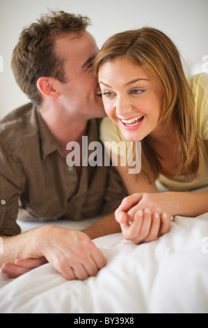 USA, New Jersey, Jersey City, Portrait of young woman lying on bed Banque D'Images