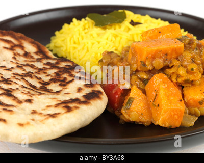 Végétarien épicé frais Curry de patate douce Dhansak avec pilaf du riz jaune et pain naan contre un fond blanc avec aucun peuple Banque D'Images