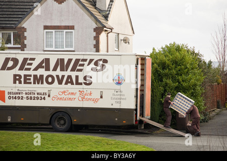 Les hommes exerçant dans un camion de meubles dans la rue devant une maison pour accueil de l'absorption. Le Nord du Pays de Galles, Royaume-Uni, Angleterre. Banque D'Images