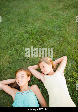 USA, New York, deux filles (10-11, 10-11) lying on grass backyard Banque D'Images