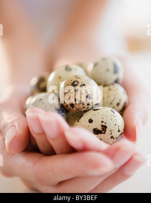 USA, New Jersey, Jersey City, Close-up view of woman's hands holding a repéré des oeufs de cailles Banque D'Images