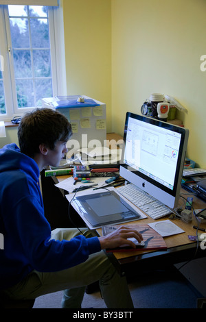 Étudiant travaillant dans sa chambre avec un bureau malpropre et un imac. Banque D'Images