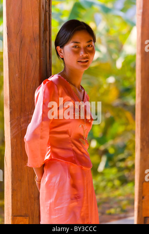 Jeune femme en robe orange Dai à plateau Research Institute, Province du Yunnan, Xishuangbanna, Chine. JMH4236 Banque D'Images