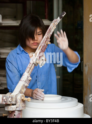 Femme à une usine de céramique à un tour de potier, préparation de l'argile dans un moule pour la cuisson Banque D'Images