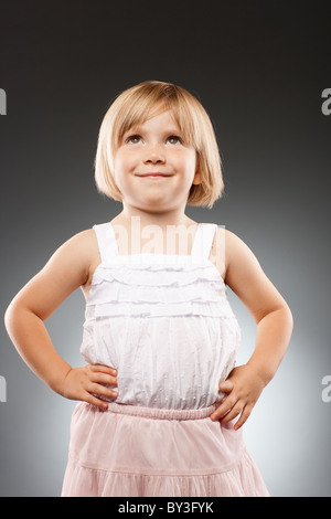 Girl (2-3) avec les mains sur la hanche et à la recherche, studio shot Banque D'Images