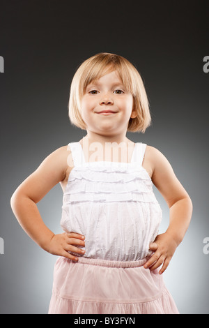 Girl (2-3) avec les mains sur la hanche et looking at camera, studio shot Banque D'Images