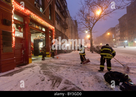 Pelleter la neige épaisse des pompiers sur la 14e rue à New York City pendant la tempête de neige à Noël 2010 record Banque D'Images