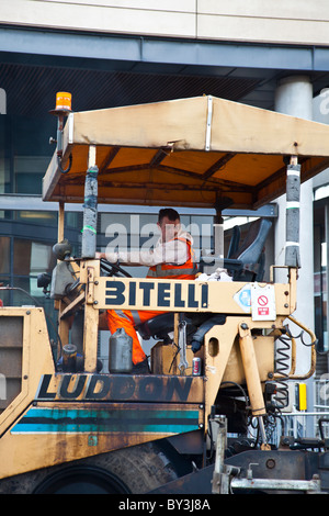 Man operating Bitelli matériel de construction routière au cours des opérations de resurfaçage des routes dans Fountainbridge, Édimbourg, Écosse Banque D'Images