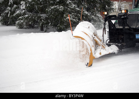 Chariot labourant la neige sur la rue de quartier dans une tempête de neige Banque D'Images