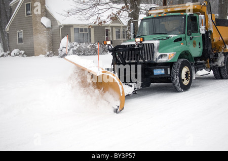 Chariot labourant la neige sur la rue de quartier dans une tempête de neige Banque D'Images