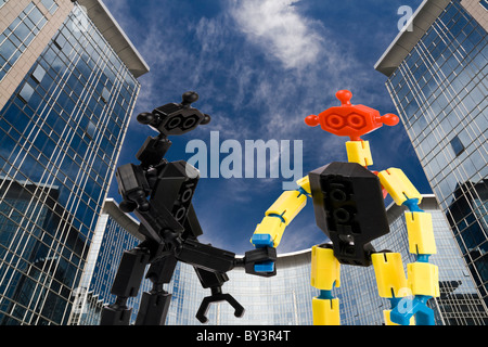 Poignée de gens briques jouet sur office building background Banque D'Images