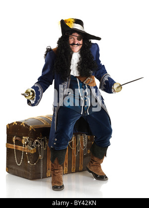 Licence et tirages sur MaximImages.com - riant pirate avec une épée et un crochet protégeant son Trésor coffre plein d'or. Isolé sur fond blanc Banque D'Images
