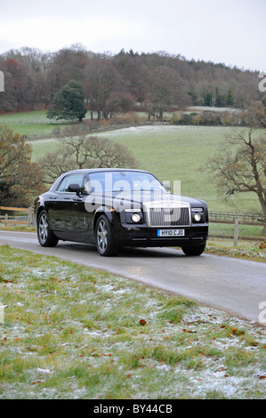 Une Rolls Royce Ghost voiture roulant à travers la campagne du Sussex de l'Ouest près de Goodwood Banque D'Images