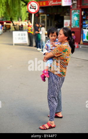 Une femme chinoise tenant une petite fille, Beijing, Chine CN Banque D'Images