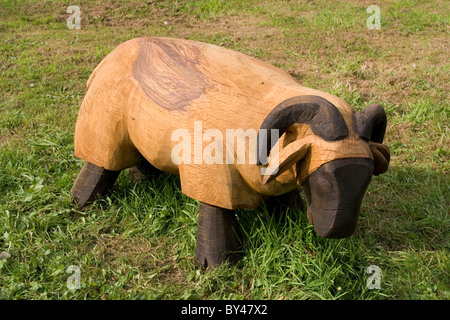 Gros plan du mouton en bois avec la face noire et les jambes, mange de l'herbe. Banque D'Images