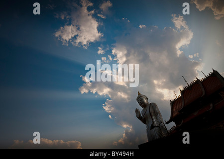 Bouddha contre ciel dramatique sur le temple dans le parc de la minorité Dai, Ganlanba (Menghan), Jinghong, Province du Yunnan, Chine. JMH4283 Banque D'Images