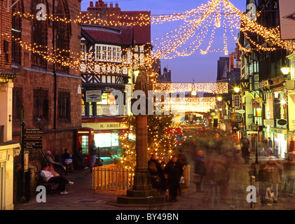 Les acheteurs de Noël sur Eastgate Street at Night, Chester, Cheshire, Angleterre, RU Banque D'Images