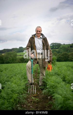 PATRICK HOLDEN, DIRECTEUR DE LA SOIL ASSOCIATION, SUR SA FERME BIO À LLANGYBI, ouest du pays de Galles. En photo avec ses carottes biologiques Banque D'Images