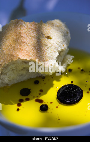 Croûte de pain trempé dans un bol d'huile d'olive et vinaigre balsamique. Banque D'Images