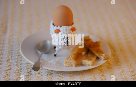 Moutons de childrens egg cup avec oeuf mollet et soldats beurré Banque D'Images