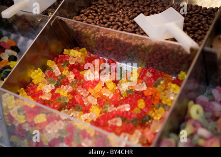 Un bac rempli de bonbons ours gummi, parmi d'autres bacs de bonbons Banque D'Images