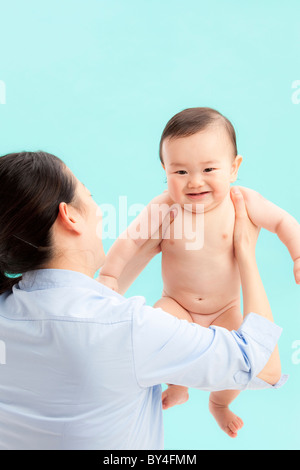 Mother Holding Up Baby Boy Banque D'Images