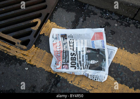 Hackney crise économique. Avec journal du journal ' Jobs ax' dans le caniveau Banque D'Images