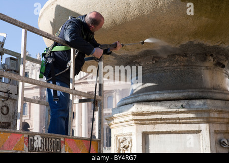 Nettoie en utilisant la pression des travailleurs de l'eau d'une machine haute fontaine à Saint Peter's square, Vatican Rome Italie Banque D'Images