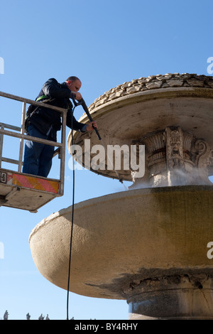 Nettoie en utilisant la pression des travailleurs de l'eau d'une machine haute fontaine à Saint Peter's square, Vatican Rome Italie Banque D'Images