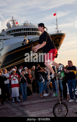 Un artiste de rue juggling que lorsque vous roulez un monocycle devant une grande foule de spectateurs à Mallory Square, Key West. Banque D'Images