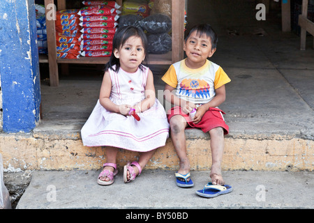 Curieux petit frère & soeur mexicaine s'asseoir gaiement dans porte de marché du village de ville de San Angel l'état d'Oaxaca au Mexique Banque D'Images