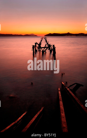 Un détruit, métallique, la mienne loading 'bain' à Alykes beach, île de Milos, au coucher du soleil Banque D'Images