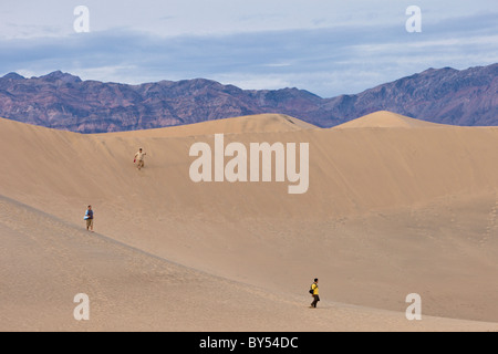 Groupe de personnes à la télévision Mesquite Sand Dunes avec l'Amargosa Montagnes dans Death Valley National Park, California, USA. Banque D'Images