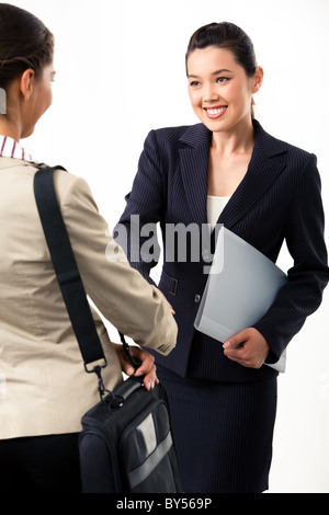 Portrait of two businesswomen shaking hands at meeting each other and smiling Banque D'Images